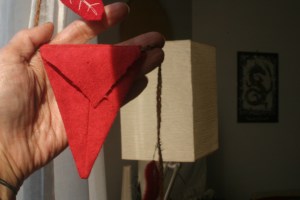 Houseproud homestead project - close-up of back of a flag strung on the red flannel garland hanging in our living room window.