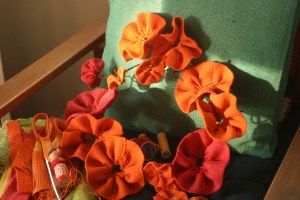 Work in progress - burlap flowers and wreath form (being kept company by thread, "needle girl" and some scraps of burlap).