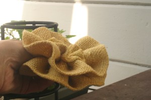 Side-view close-up of yellow burlap flower to be used in fall-inspired wreath