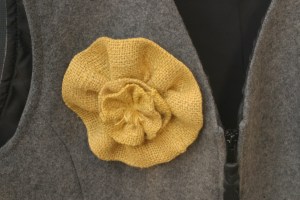 I made a lovely little flower pin out of some of the yellow burlap flowers that I have been playing around with (the burlap flowers that will eventually turn into a fall-inspired wreath for the Houseproud homestead's living room). The back of the pin looks almost as finished as its front.