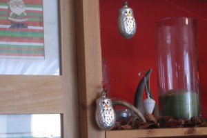 A close-up of the hutch, showing the glass owls (another WES score), strung on burlap twine.  That little santa in the upper left corner is a paper ornament from my childhood.  I "framed" 15 such ornaments in the folding screen this year (I used Christmas gift wrap as background), and I think this will become a new tradition.  I have no idea what I'll put in the screen this weekend when the Christmas decorations come down.  Hmm.  Ideas, anyone?  