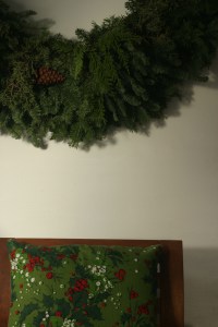 We  don't have enough room in our tiny apartment for a tree, so we hang wreaths or fir boughs instead.  I hung a HUGE wreath on the wall next to the tv this year.  I was going to decorate the wreath, but I decided to keep it bare.  It's quiet, unlike the santas and the elves.  The wreath smelled SO good when I first brought it into the house - like being in a forest.  I still get a whiff of forest when I walk past it.  Mmmmm, I do like that smell ...